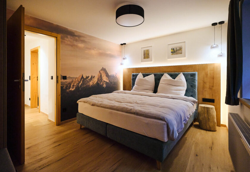 Das Schlafzimmer mit Bett, Polstern und kuscheligen Decken
