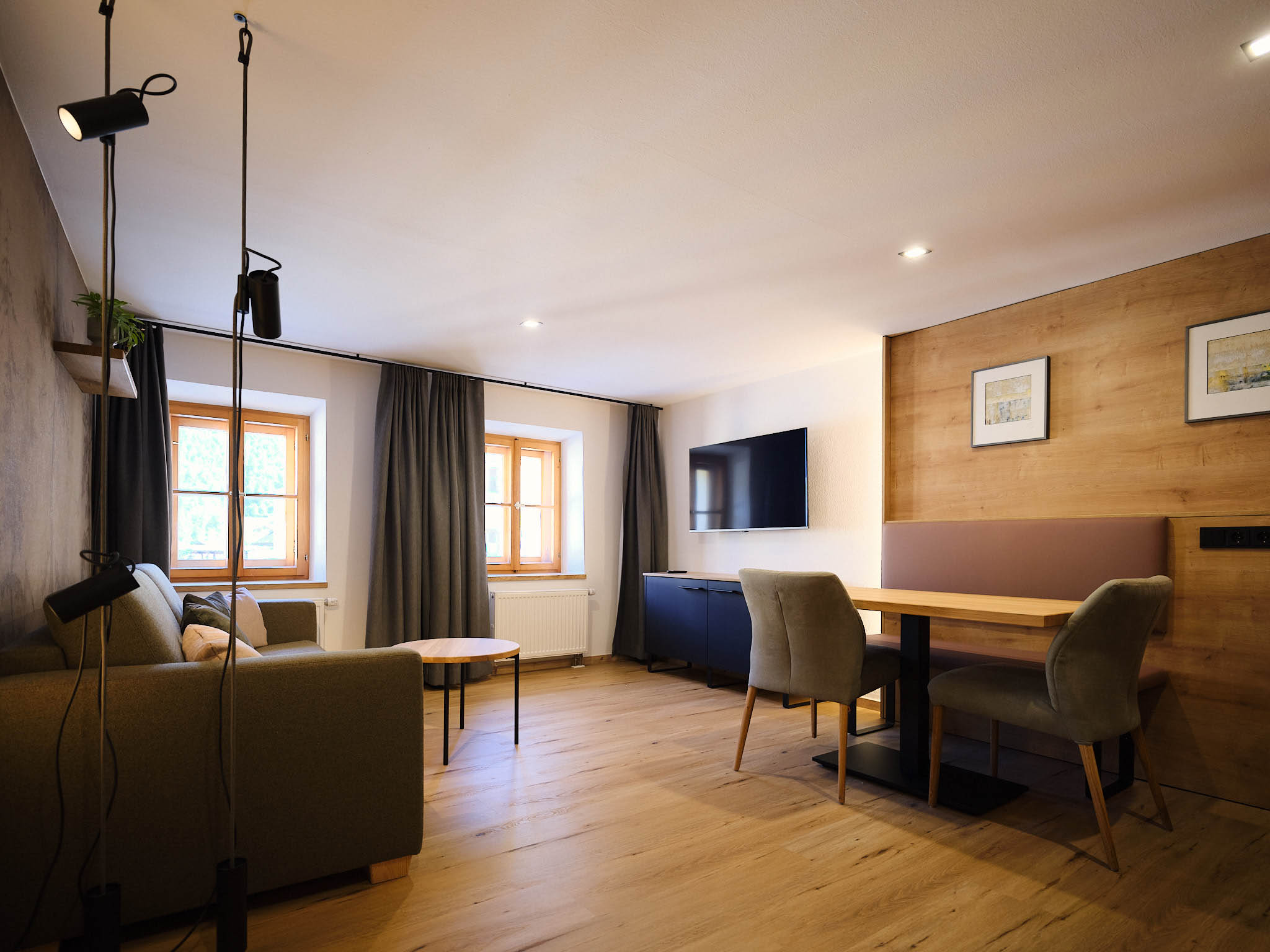 Ansicht des Wohnzimmers mit Tisch, Fernseher und Sofa