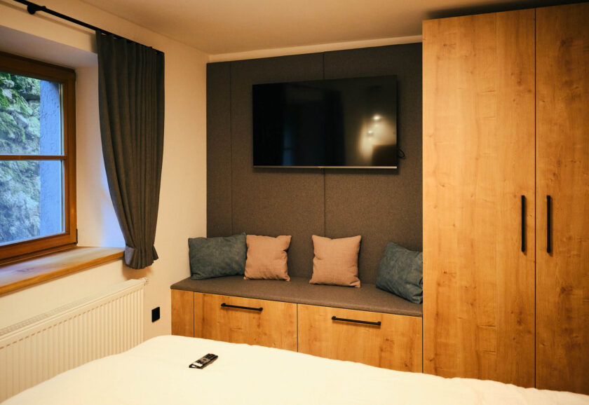 Blick auf die Schränke und den Fernseher im Schlafzimmer des Neumeier Apartments